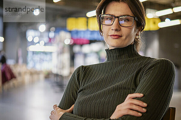 Confident businesswoman wearing eyeglasses in cafe