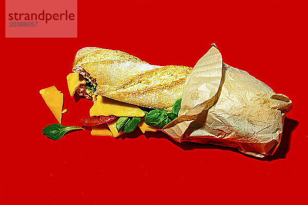 Cheddar cheese and vegetable sandwich on red background