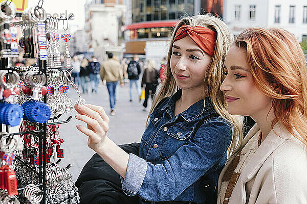 Friends shopping for key rings in London city