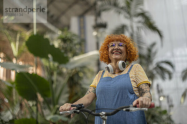 Happy redhead senior woman with bicycle