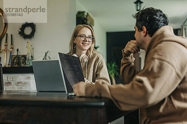 Software programmers talking near laptop at home office