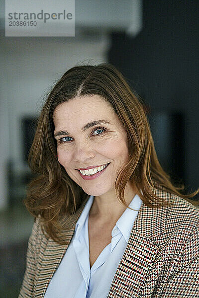 Confident mature businesswoman in blazer at office