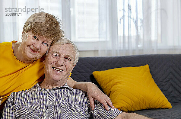 Smiling senior couple sitting at home