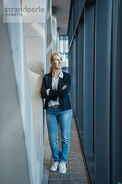 Contemplative businesswoman standing near columns