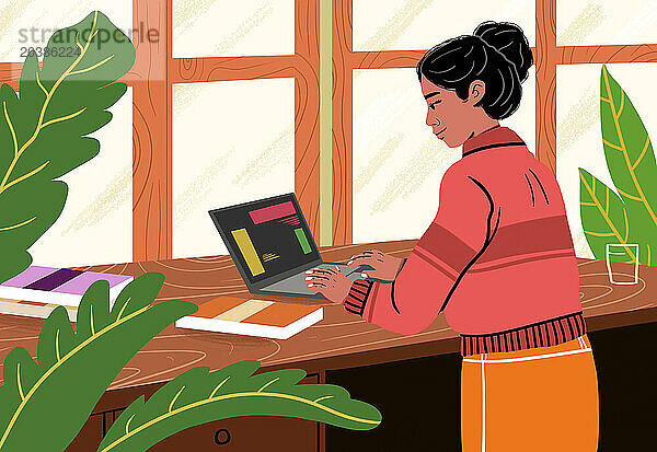 Businesswoman using laptop on table working from home