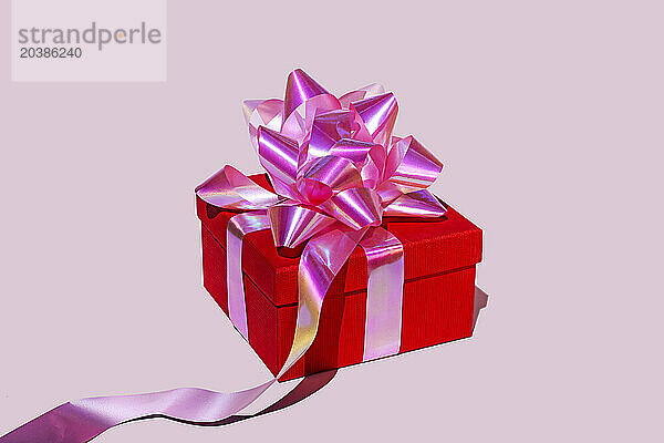 Red gift box against pink background