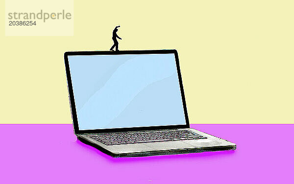 Illustration of man balancing on oversized laptop