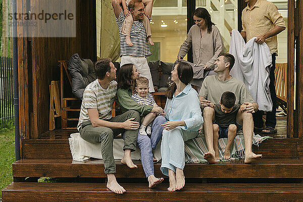 Happy friends and family spending leisure time together on porch