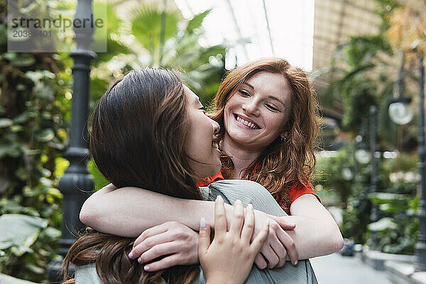 Happy young woman embracing friend