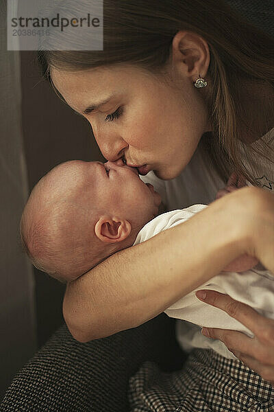 Mother kissing baby boy at home