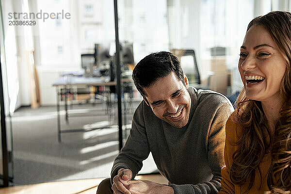 Cheerful business people laughing in office