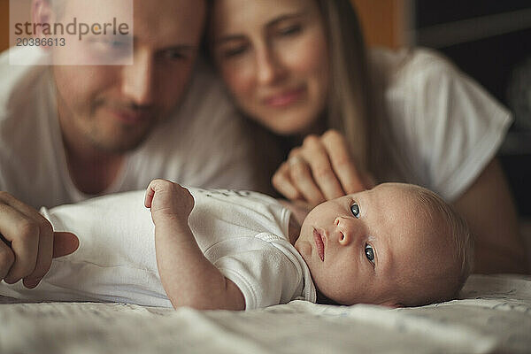 Mother and father admiring baby boy at home