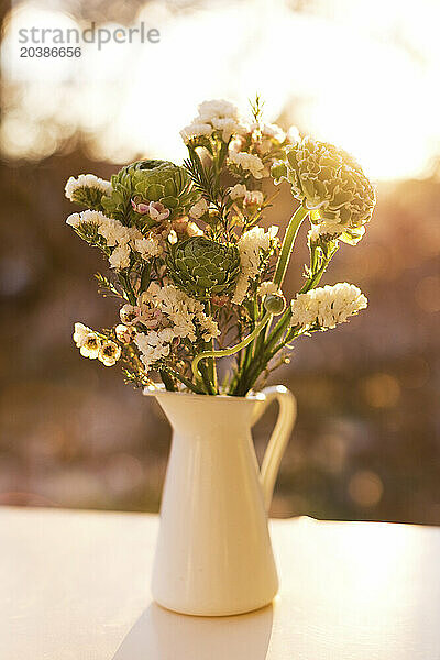 Bouquet of green ranunculus and white chamelaucium flowers