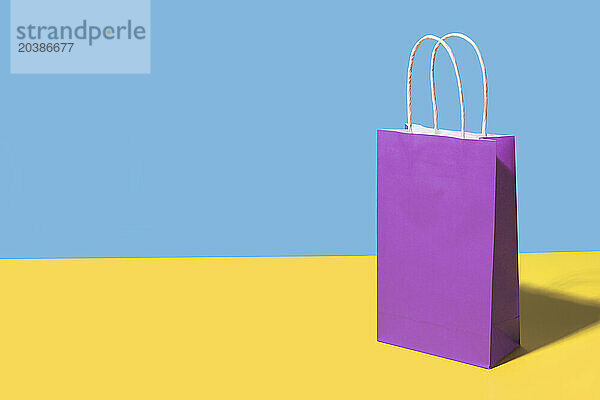 Purple shopping bag against colored background