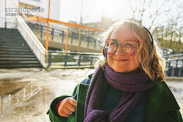 Smiling woman wearing eyeglasses and day dreaming at sunny day