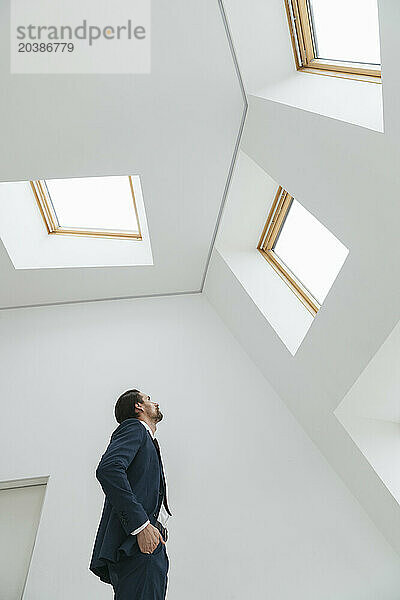 Businessman looking at window in office