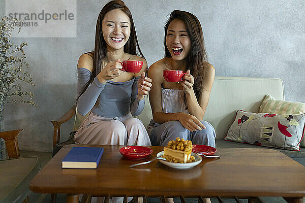 Laughing friends having coffee at restaurant