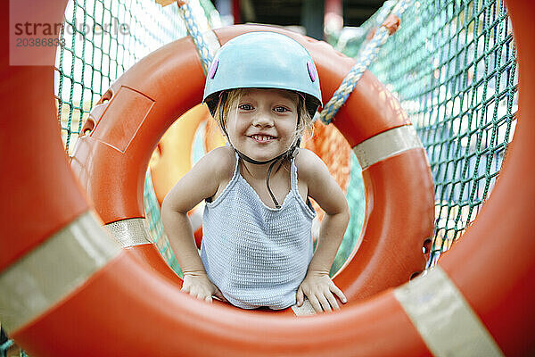 Smiling girl playing at rope park