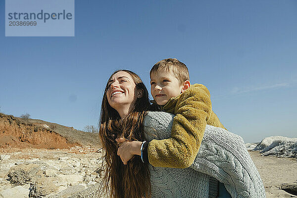 Happy woman having fun with son at sunny day