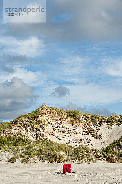 Germany  Schleswig-Holstein  Amrum  Clouds over single hooded beach chair standing on empty beach