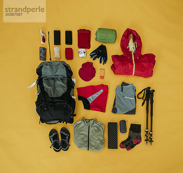 Travel kit for hiking organized on yellow background