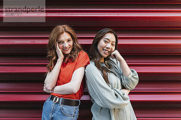 Smiling friends posing near shutter