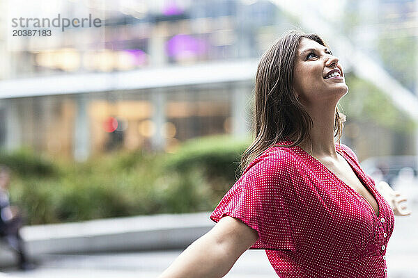 Happy young woman in front of building