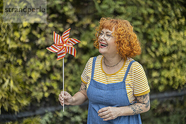 Happy redhead woman with pinwheel toy