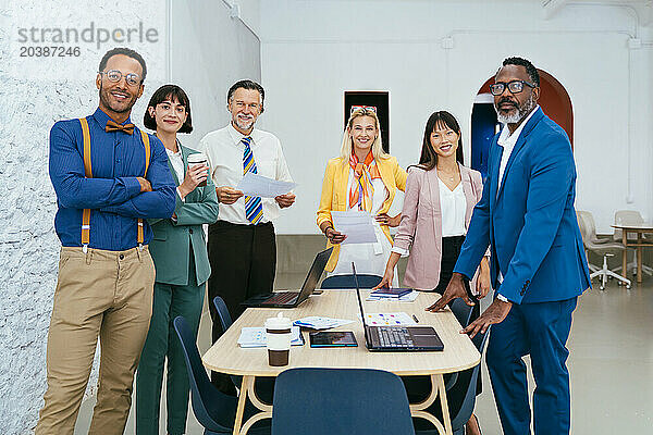 Confident business colleagues standing together at work place