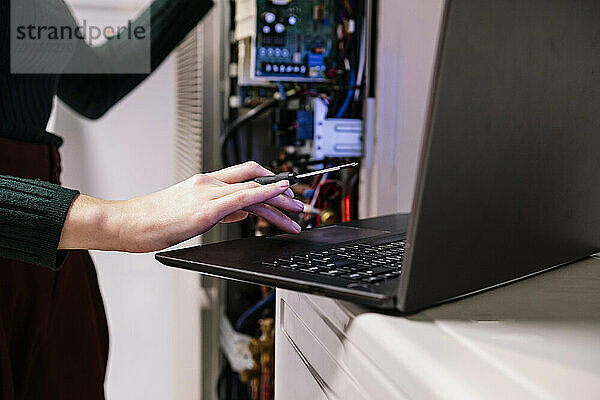 Engineer using laptop in server room