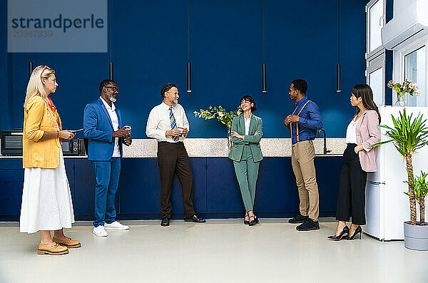 Business colleagues discussing with each other in coffee break at office