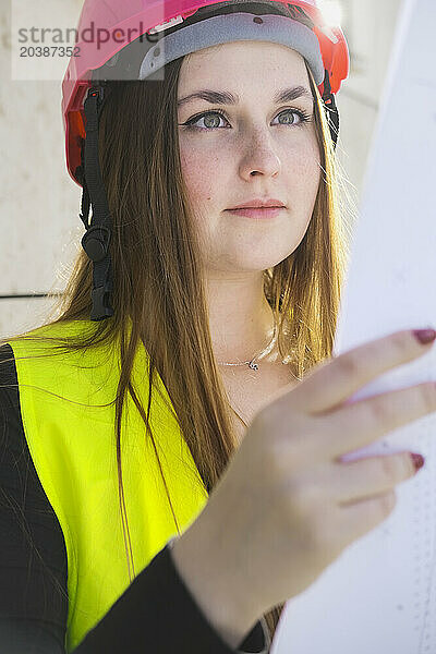 Focused young geodesist reading document