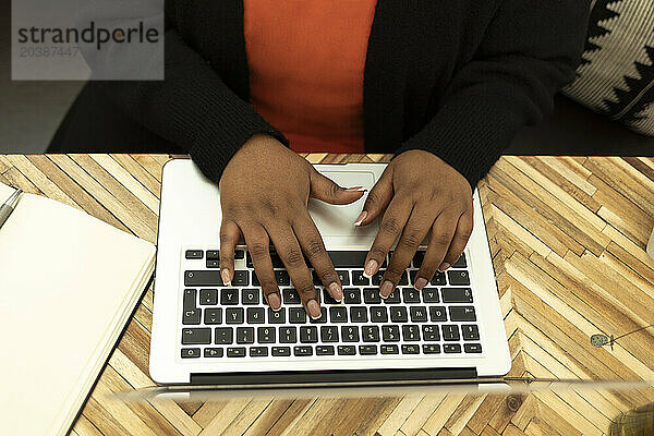Freelancer typing on laptop at cafe