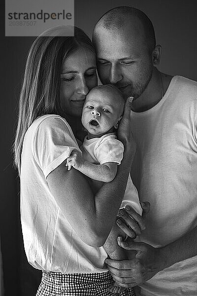 Mother and father holding baby boy at home