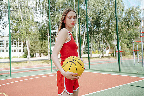 Basketball player with ball in schoolyard