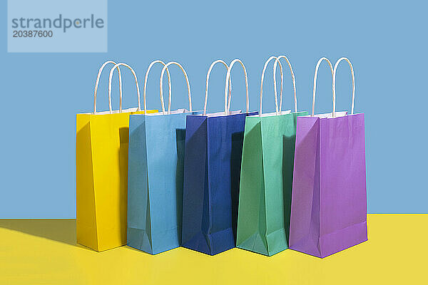 Colorful shopping bags arranged against colored background