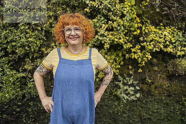 Smiling redhead senior woman with hands on hips