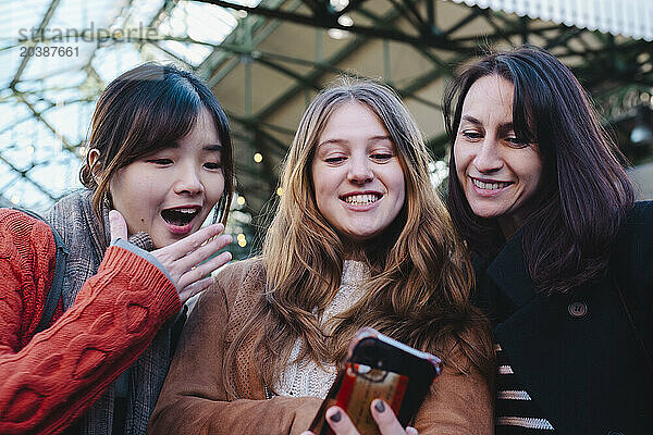 Happy friends taking selfie through smart phone