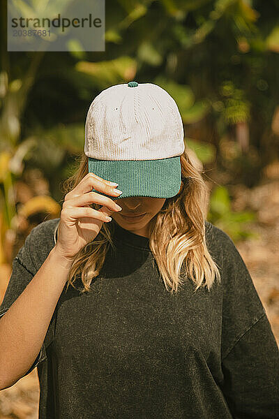 Woman with blond hair wearing cap on sunny day