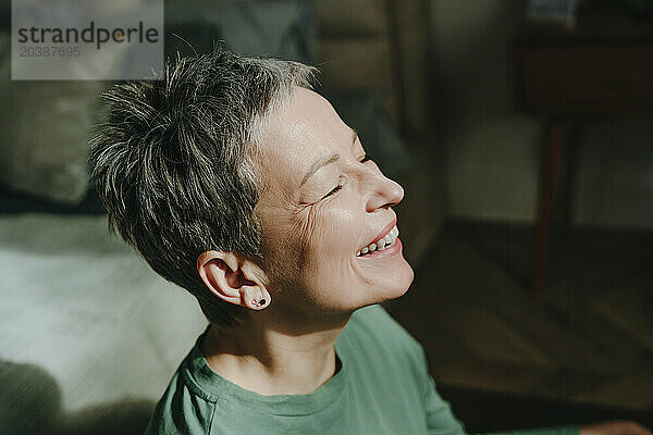 Happy woman with gray hair at home