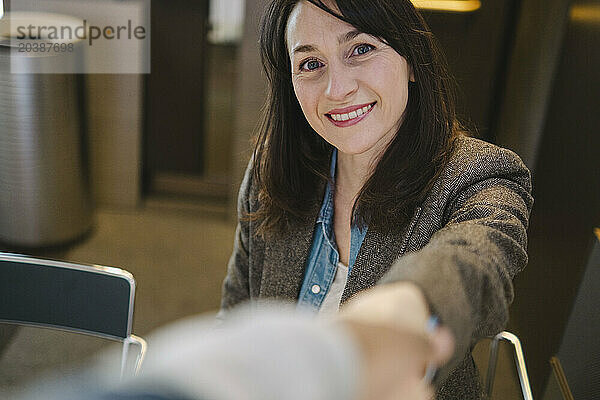 Smiling mature businesswoman wearing brown blazer