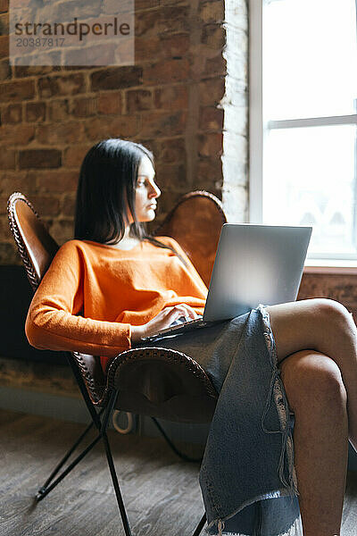 Thoughtful businesswoman sitting with laptop at cafe