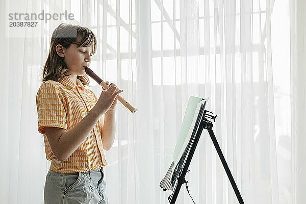 Girl playing flute at home