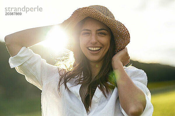Happy young woman wearing hat on sunny day
