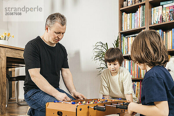 Father playing foosball with children