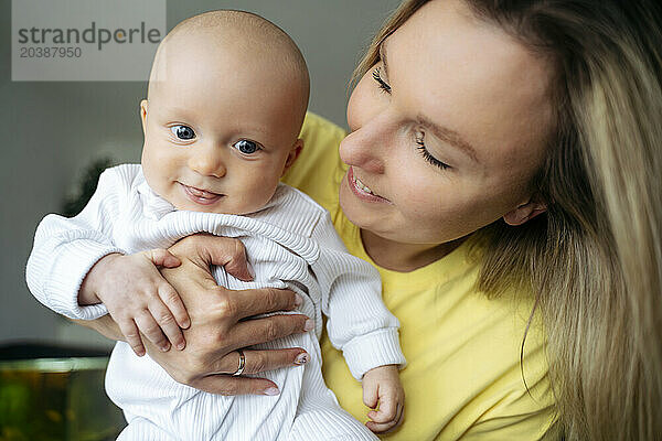 Smiling blond mother with son at home