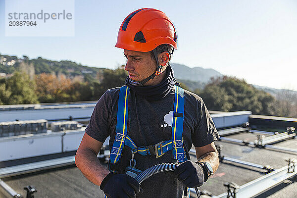 Mature technician wearing protective workwear on sunny day