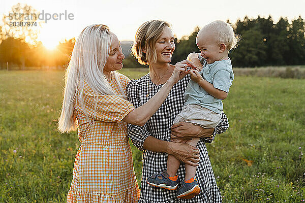 Happy women playing with toddler in park