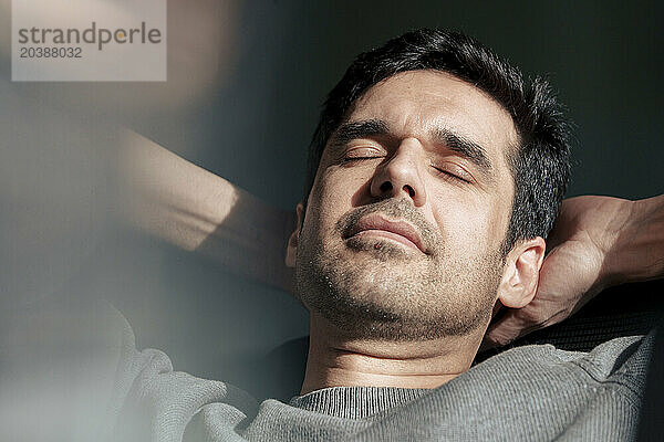 Businessman relaxing with hands behind head