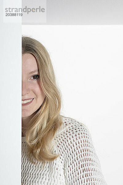 Smiling blond teenage girl against white background